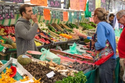 Vibrant farmers market with fresh produce and shoppers.