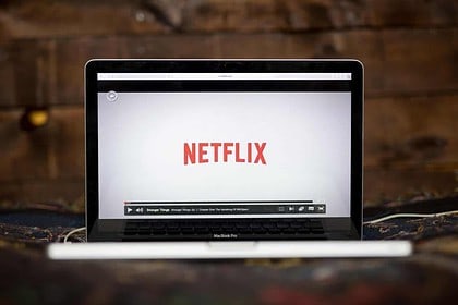 Laptop displaying Netflix logo on screen.