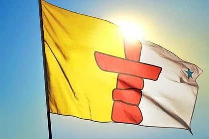 Nunavut territory flag waving against the sun, Canada.
