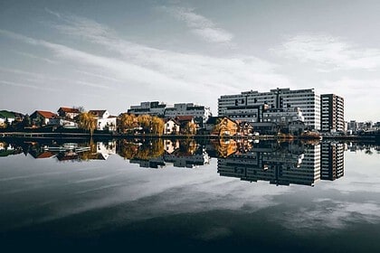 City skyline reflected in calm waterfront at dusk