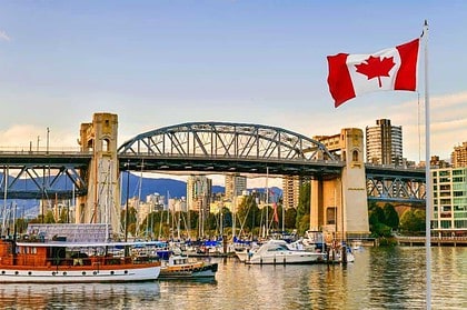 Vancouver harbor with boats and Canadian flag.