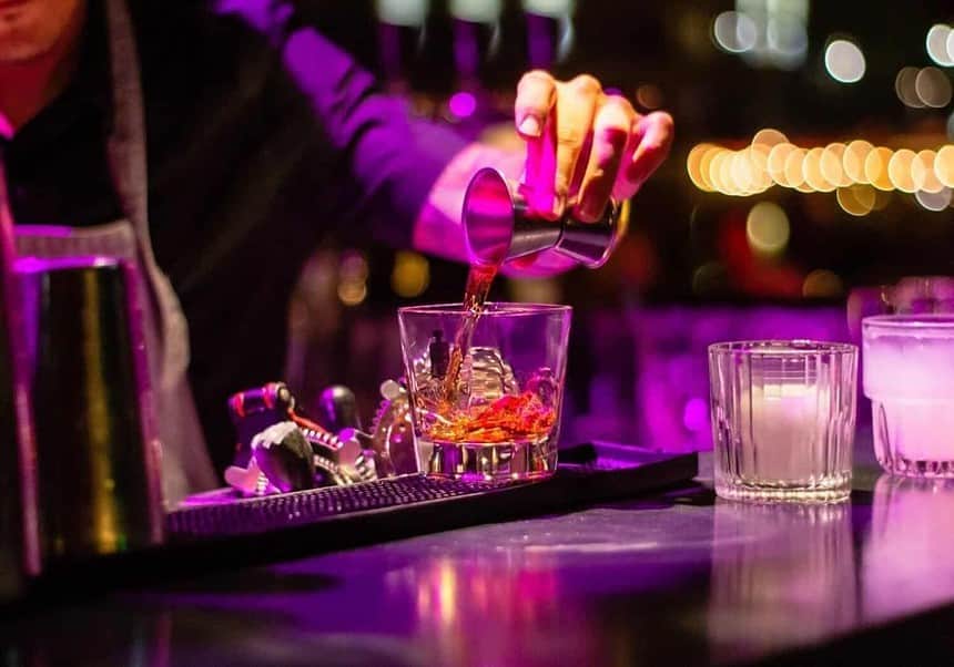 Bartender preparing cocktail at busy nightlife bar