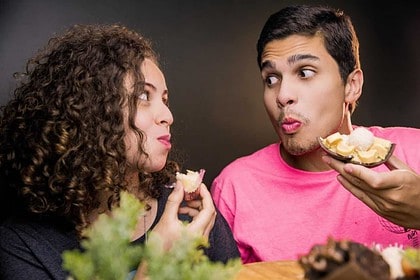 Couple enjoying a playful meal together.