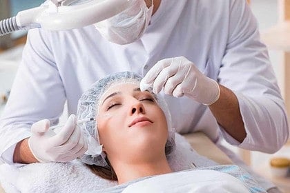Patient receiving consultation at aesthetic medicine clinic.