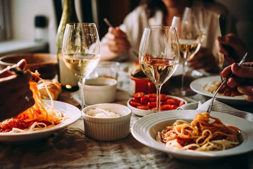 Friends enjoying a cozy pasta dinner at home.
