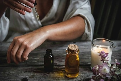 Oregano oil is kept in containers, and some fresh and dried oregano herbs are beside it.