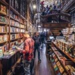 Inside Lello Bookstore Porto, famous ornate shelves and visitors.