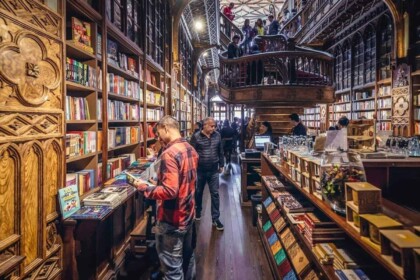 Inside Lello Bookstore Porto, famous ornate shelves and visitors.