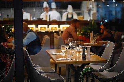 Fine dining setup at upscale Oakville restaurant with guests and chefs.