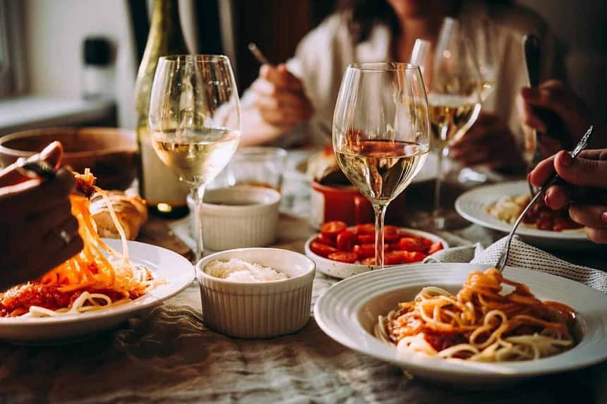 Friends enjoying a cozy pasta dinner party at home.