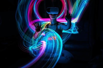 Person experiencing vibrant virtual reality gaming environment.