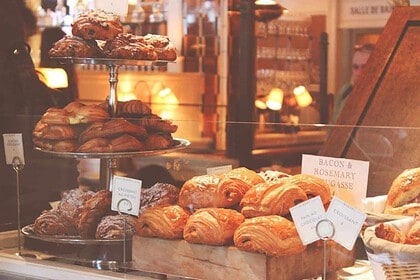 Assortment of fresh bread and croissants in bakery display.