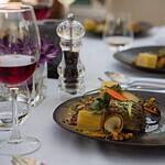 Gourmet dinner table with wine and elegant setting.