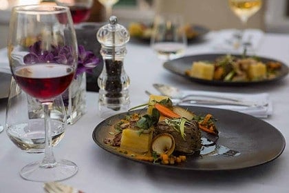 Gourmet dinner table with wine and elegant setting.