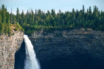 Majestic waterfall in forested landscape during daylight.