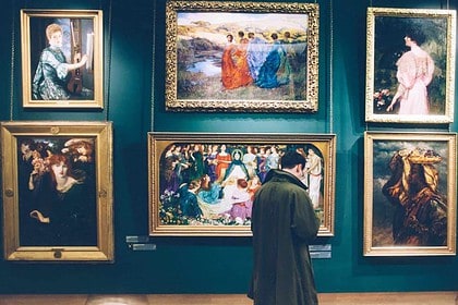 Person viewing classic paintings in an art museum.