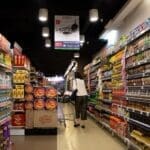 Customer shopping in grocery store aisle.