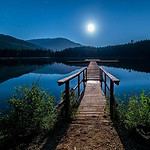 Serene lakeside pier under moonlight in British Columbia.