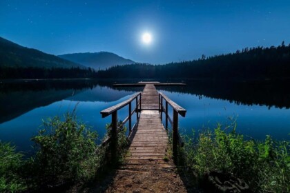 Serene lakeside pier under moonlight in British Columbia.