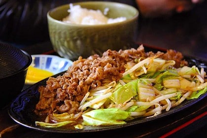 Savory pan-fried beef with leeks on a plate.