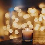 Candlelight with warm bokeh lights in soft focus background.