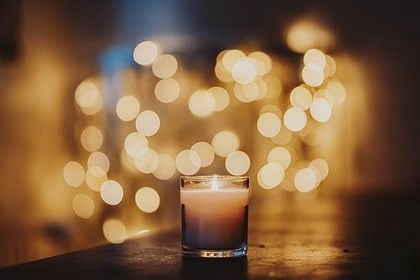 Candlelight with warm bokeh lights in soft focus background.