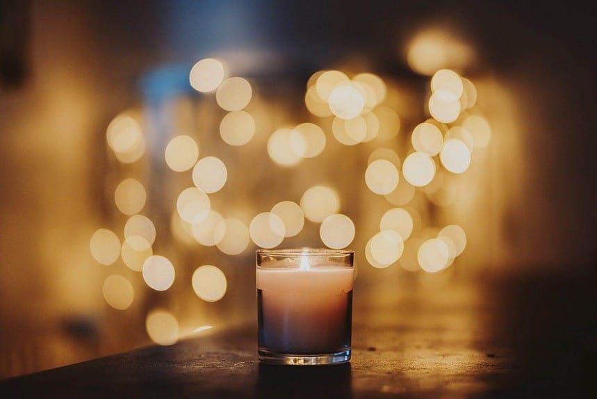 Candlelight with warm bokeh lights in soft focus background.