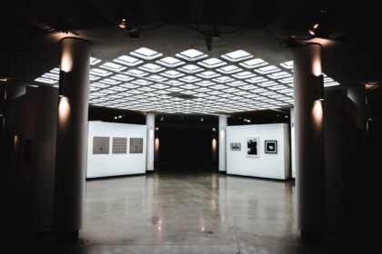 Modern art gallery interior with illuminated ceiling and artwork displays.
