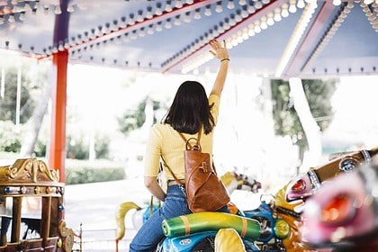 Woman waving while riding on a merry-go-round.