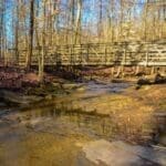 Autumnal scene of a creek with a wooden bridge in Cuyahoga Valley National Park.