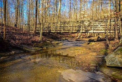 Autumnal scene of a creek with a wooden bridge in Cuyahoga Valley National Park.