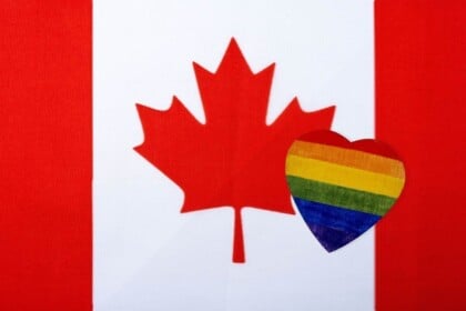 Canadian flag with a rainbow-colored heart overlay.