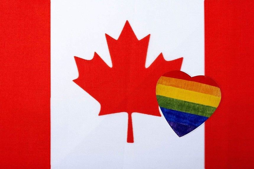 Canadian flag with a rainbow-colored heart overlay.