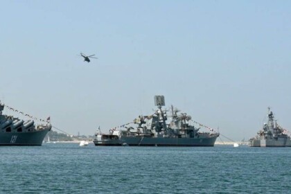 Fleet of naval warships on the ocean with helicopter.