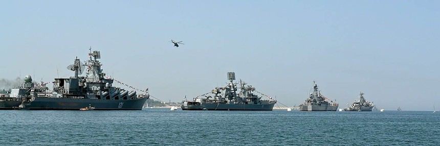 Fleet of naval warships on the ocean with helicopter.