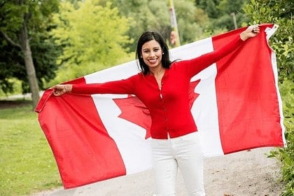 Woman smiling with Canadian flag outdoors