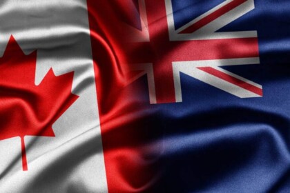Canadian and New Zealand flags intertwined in union.