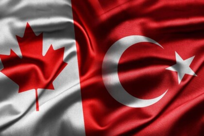 Canadian and Turkish flags intertwined, symbolizing diplomatic relations.