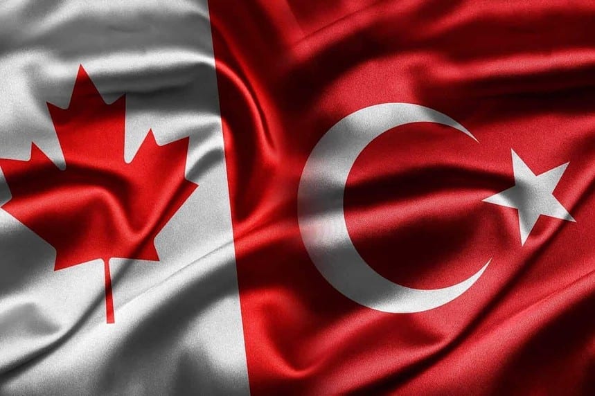 Canadian and Turkish flags intertwined, symbolizing diplomatic relations.