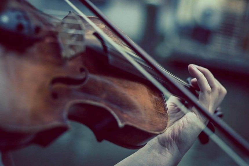 Intimate candlelit violin performance close-up.