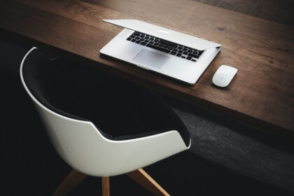 Minimalist office desk with laptop and chair.