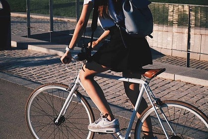 Stylish urban cyclist on city bike path.