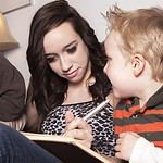 Babysitter with children reading and writing.