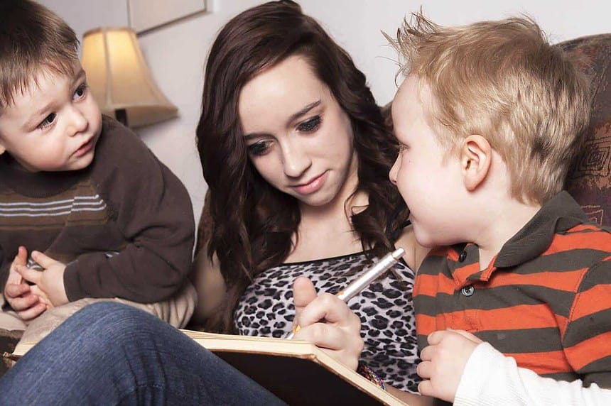Babysitter with children reading and writing.