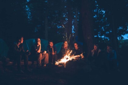 Friends enjoying a cozy campfire in the forest at night.