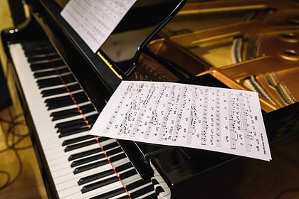 Grand piano with sheet music, evoking classical music elegance.