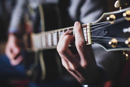 Guitarist playing at a candlelit tribute event in Toronto.