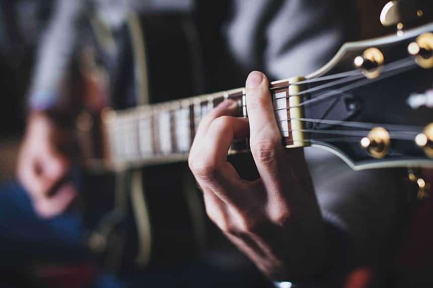 Guitarist playing at a candlelit tribute event in Toronto.