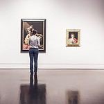 Art enthusiast admiring paintings at Mississauga gallery exhibit.