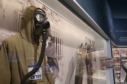 Historical police uniform and gas mask on display at a museum.